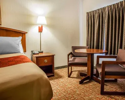 a hotel room with a bed and a table and chairs at Econo Lodge Douglassville-Pottstown in Douglassville