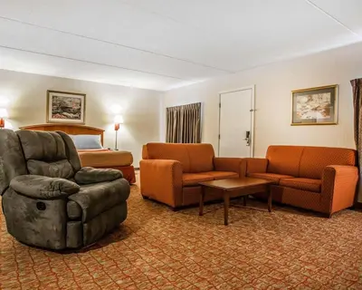 a hotel room with a couch and chairs and a bed at Econo Lodge Douglassville-Pottstown in Douglassville