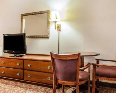 a room with a table and a television on a dresser at Econo Lodge Douglassville-Pottstown in Douglassville