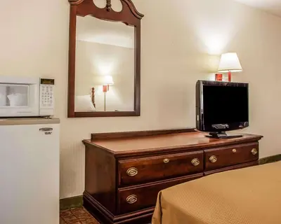 a room with a television on a dresser with a microwave at Econo Lodge Douglassville-Pottstown in Douglassville