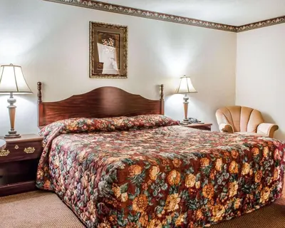 a hotel room with a bed and a chair at Econo Lodge Frackville in Frackville
