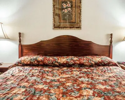 a bed with a floral comforter in a bedroom at Econo Lodge Frackville in Frackville