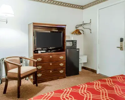 a hotel room with a television and a chair at Econo Lodge Frackville in Frackville
