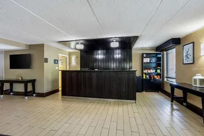 a lobby with a waiting area with tables and a tv at Best Western Harrisburg North Hershey in Harrisburg