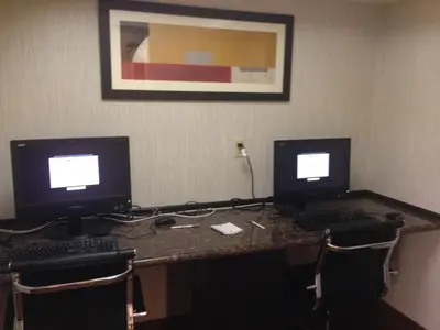 two computer monitors sitting on top of a desk at Best Western Harrisburg North Hershey in Harrisburg