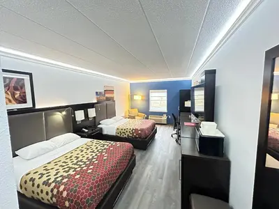 a hotel room with two beds and a desk at Baymont by Wyndham Lancaster PA Dutch Country in Lancaster