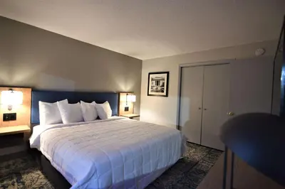 a hotel room with a large bed and two lamps at Baymont by Wyndham Pine Grove I-81 in Pine Grove