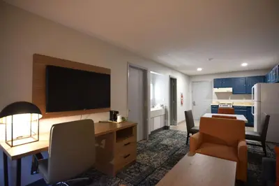 a living room with a desk with a television on it at Baymont by Wyndham Pine Grove I-81 in Pine Grove