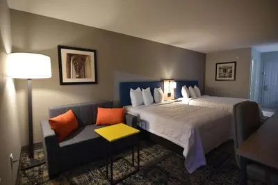 a hotel room with two beds and a couch at Baymont by Wyndham Pine Grove I-81 in Pine Grove