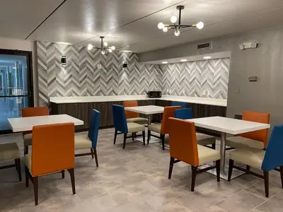 a dining room with tables and chairs and a counter at Baymont by Wyndham Pine Grove I-81 in Pine Grove