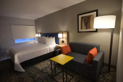 a hotel room with a bed and a couch at Baymont by Wyndham Pine Grove I-81 in Pine Grove