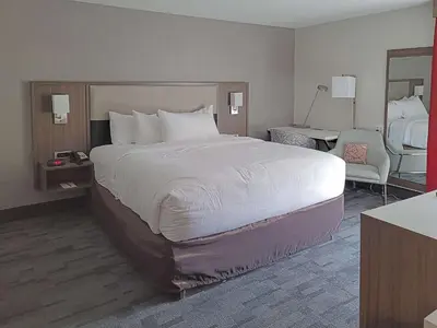 a hotel room with a large bed and a chair at Comfort Inn & Suites Wyomissing-Reading in Wyomissing
