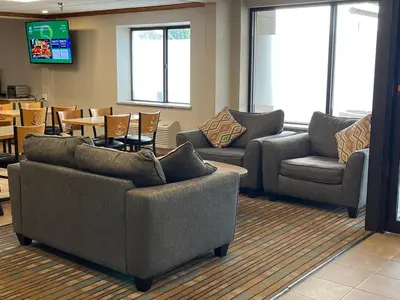 a waiting room with couches and chairs and a television at Quality Inn Wilkes-Barre near Arena in Wilkes-Barre