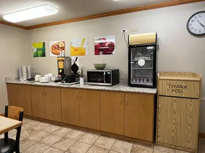 a kitchen with a counter with a microwave and a clock at Quality Inn Wilkes-Barre near Arena in Wilkes-Barre