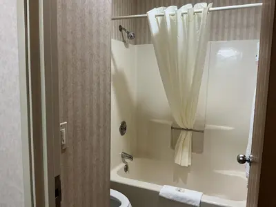 a bathroom with a tub and a toilet with a shower curtain at Quality Inn Wilkes-Barre near Arena in Wilkes-Barre