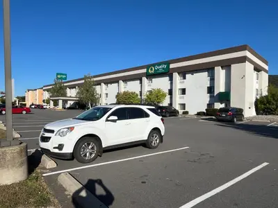 a white car parked in a parking lot in front of a store at Quality Inn Wilkes-Barre near Arena in Wilkes-Barre