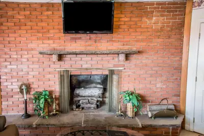 a brick fireplace with a television on a brick wall at Econo Lodge Williamsport in Williamsport