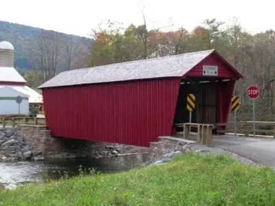 a red barn with a stop sign next to a road at Quality Inn Mill Hall - Lamar in Clintondale