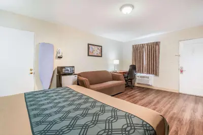 a hotel room with a bed and a couch and a desk at Econo Lodge Mechanicsburg - Harrisburg West in Mechanicsburg