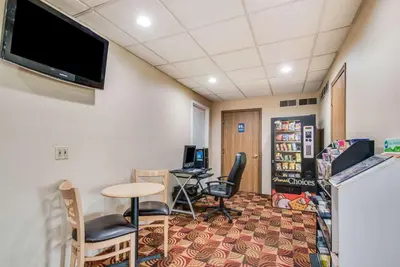 a waiting room with a table and chairs and a tv at Econo Lodge Mechanicsburg - Harrisburg West in Mechanicsburg