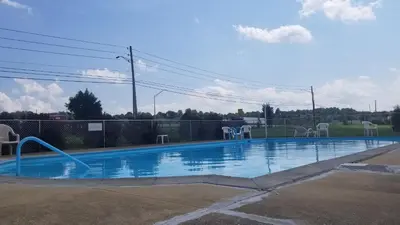 an empty swimming pool with chairs and a fence at Econo Lodge Mechanicsburg - Harrisburg West in Mechanicsburg