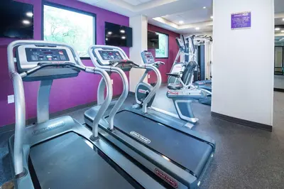 a row of treadmills in a gym with purple walls at Home2 Suites By Hilton King Of Prussia Valley Forge in King of Prussia