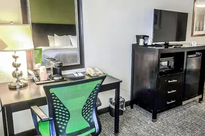a hotel room with a desk with a bed and a mirror at Quality Inn Selinsgrove in Selinsgrove