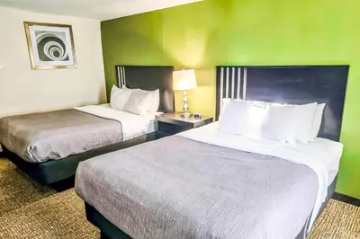 two beds in a hotel room with green walls at Quality Inn Selinsgrove in Selinsgrove