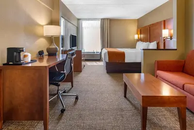 a hotel room with a bed and a desk and a room at Comfort Suites Bethlehem Near Lehigh University and LVI Airport in Bethlehem