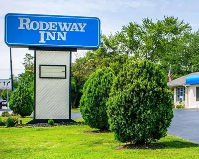 a blue road way inn sign next to a bush at Rodeway Inn Dillsburg in Dillsburg