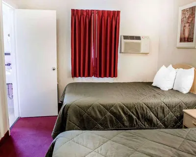 a room with a bed and a window with a red curtain at Rodeway Inn Dillsburg in Dillsburg