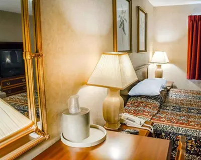a hotel room with a bed and a lamp on a table at Rodeway Inn Dillsburg in Dillsburg