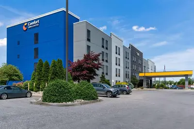 a blue building with cars parked in a parking lot at Comfort Inn & Suites York North in York