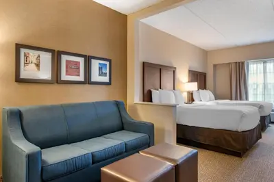 a hotel room with a bed and a couch at Comfort Suites Downtown Carlisle in Carlisle