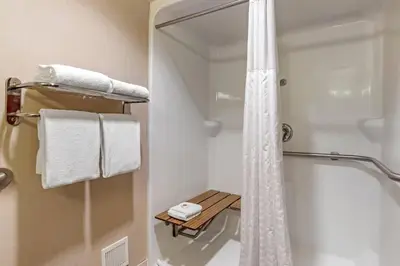 a bathroom with a shower and white towels at Comfort Suites Downtown Carlisle in Carlisle