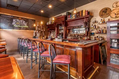 a bar with a row of stools in a restaurant at Comfort Suites Downtown Carlisle in Carlisle