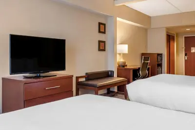 a hotel room with a bed and a flat screen tv at Comfort Suites Downtown Carlisle in Carlisle