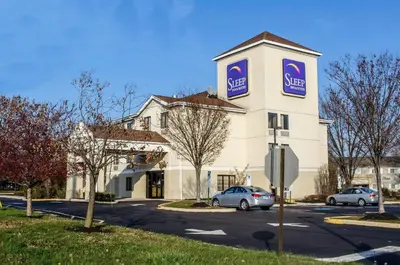 a large white building with a sign on it at Sleep Inn & Suites Bensalem in Bensalem