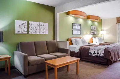 a hotel room with a bed and a couch at Sleep Inn & Suites Bensalem in Bensalem