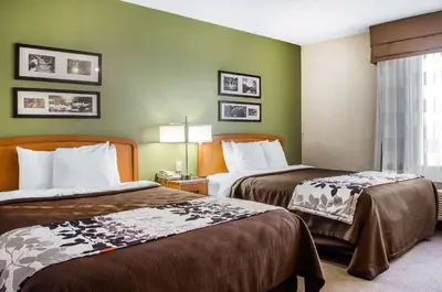 two beds in a hotel room with green walls at Sleep Inn & Suites Bensalem in Bensalem