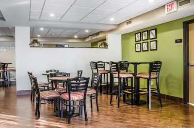 a dining room with tables and chairs and green walls at Sleep Inn & Suites Bensalem in Bensalem