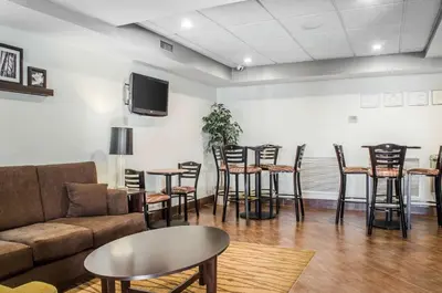 a living room with a couch and tables and chairs at Sleep Inn & Suites Bensalem in Bensalem