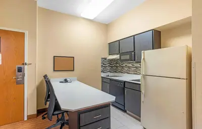 a kitchen with a refrigerator and a table with chairs at Extended Stay America Suites - Lancaster County in Mountville