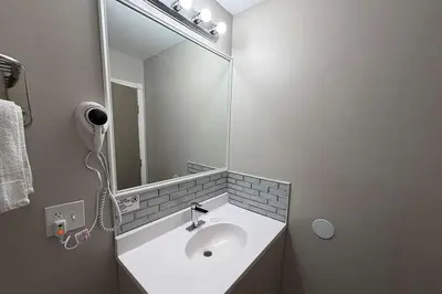 a bathroom with a white sink and a mirror at Days Inn by Wyndham Moosic in Moosic