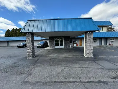 a building with a parking lot with cars parked at Days Inn by Wyndham Moosic in Moosic