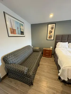 a bedroom with a bed and a couch in it at Days Inn by Wyndham Moosic in Moosic