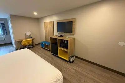 a hotel room with a bed and a flat screen tv at Days Inn by Wyndham Moosic in Moosic