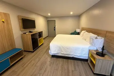 a hotel room with a bed and a flat screen tv at Days Inn by Wyndham Moosic in Moosic