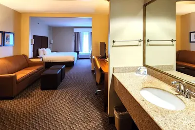 a hotel room with a bathroom with a sink and a bed at Comfort Inn & Suites Mount Pocono in Mount Pocono