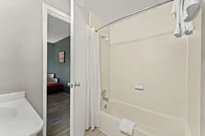 a white bathroom with a shower and a sink at Knights Inn Montgomeryville in Montgomeryville